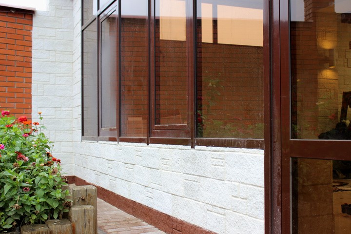 Installation of manufactured stone veneer over sand-lime brick surfaces